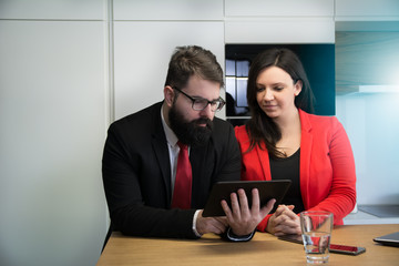 Two young colleagues looking at the Tablet