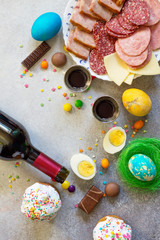 Easter meal Breakfast. Easter cake, painted eggs, red wine (Cahors) and delicious delicatessen on table. Top view flat lay background. Copy space.