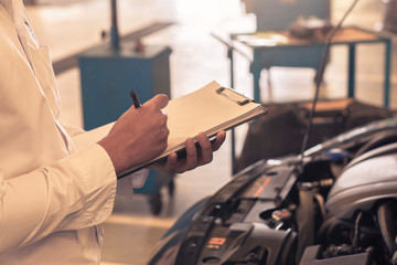 This career man saleman business inspection writing note on notepad or book, paper with car blurry...