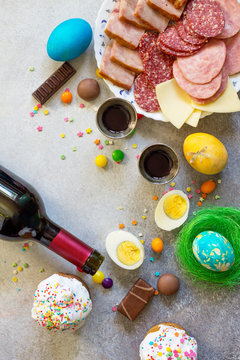 Easter meal Breakfast. Easter cake, painted eggs, red wine (Cahors) and delicious delicatessen on table. Top view flat lay background. Copy space.