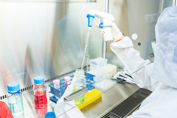 A scientist in sterile coverall gown Doing biological research in clean environmental. Cleanroom...
