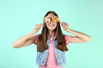 Young girl with lollipops on mint background