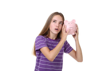 Young girl holding pink piggybank on white background