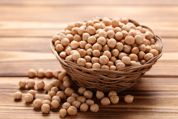 Chickpeas in basket on brown wooden table