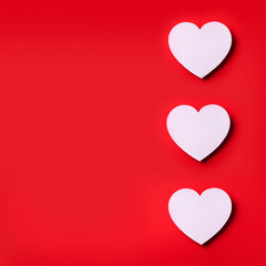 White heart cutted from paper over red background with copy space. Top view. Valentine's Day. Love, date, romantic concept. Square crop