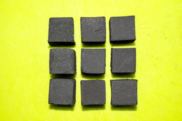coconut coal cubes on bright green background