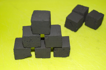 coconut coal cubes on bright green background