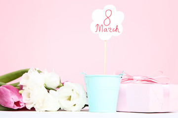 Text 8 March with flowers and gift box on pink background