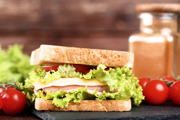 Tasty sandwich with fresh vegetables on wooden table