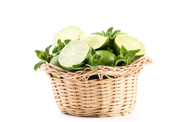 Ripe limes in basket isolated on white background