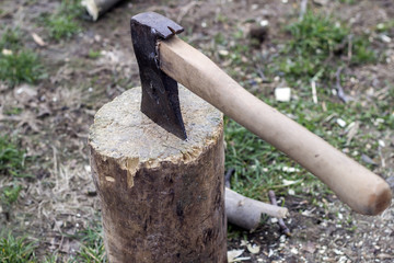 The ax is stabbed with a blade into the stump. Ax with wooden handle.