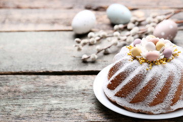 Easter cake with eggs and tree branches on grey wooden table