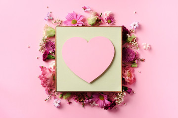 Frame of pink flowers over punchy pastel background. Valentines day, Woman day concept. Spring or summer banner with copy space