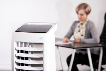 Air purifier in the office. A woman works in an office with air conditioning. Caring for employees....