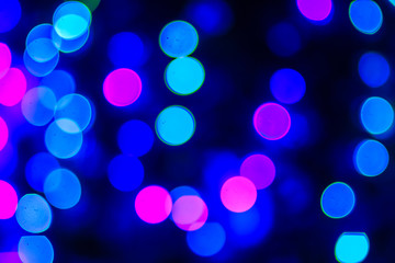 Beautiful blue bokeh abstract light background. Wonderful Defocused abstract blue christmas background. Abstract christmas lights as background in the night with noise grain and poor light.