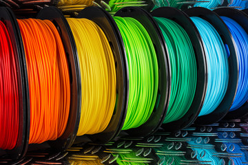 colorful bright  row of spool 3d printer filament black metal background - obrazy, fototapety, plakaty
