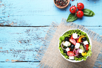 Vegetable salad in bowl with spices and tomatoes on wooden table