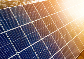 Close-up surface of lit by sun blue shiny solar photo voltaic panels. System producing renewable...