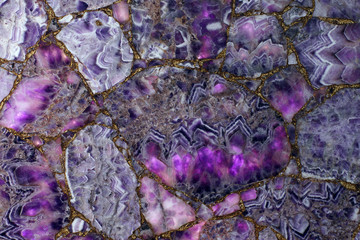 Natural purple amethyst backlit, the light highlights how translucent parts of the stone and it becomes pink