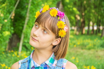 Portrait of a cute pensive, dreamy teenage girl with a wreath of flowers on her head