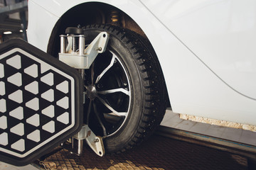 A Car on the Car Steering Wheel Balancer and Calibrate with laser reflector attach on each tire to...