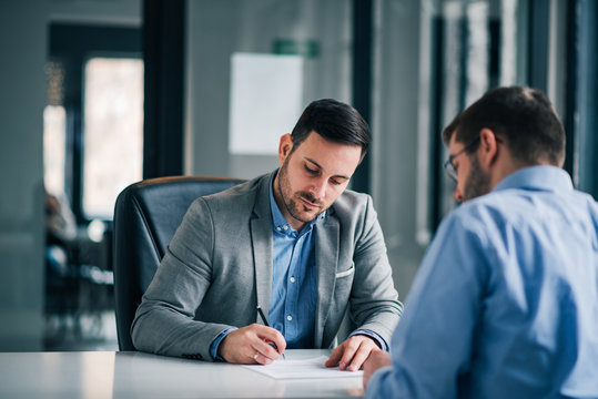 Two business men on meeting in the office, signing contract.