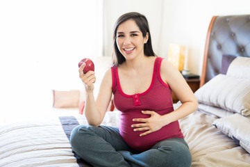 Fototapeta na wymiar Expectant Woman Enjoy Snacking On An Apple