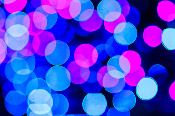 Beautiful blue bokeh abstract light background. Wonderful Defocused abstract blue christmas background. Abstract christmas lights as background in the night with noise grain and poor light.