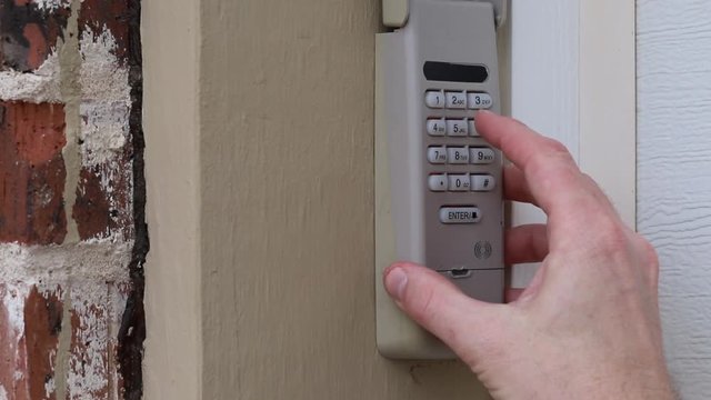 Hand entering secret code on Keypad used on a garage door entrance to a home - security keypad - security code