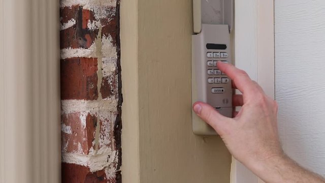 Finger entering code on Keypad used on a garage door entrance to a home - security keypad - security code