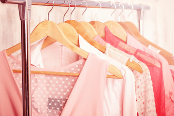 coral womens clothes on wood hangers on rack in a fashion store. . closet women dresses, blouses