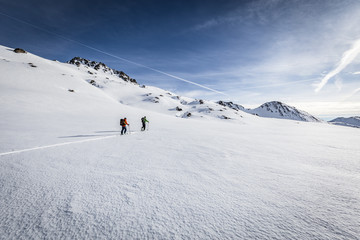Skitour im Winter in den Alpen unter blauem Himmel