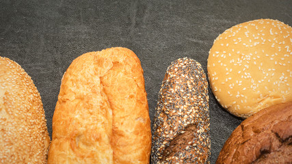 Paper bag with bread on dark background, Various fresh bread