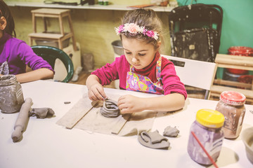 Little Girl At Pottery Workshop Working With Clay