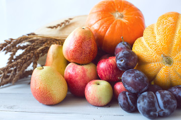Still life of fresh fruit in a wicker basket and wheat.