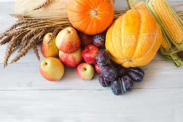 Still life of fresh fruit in a wicker basket and wheat.