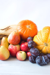 Still life of fresh fruit in a wicker basket and wheat.