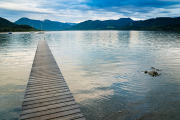 Picturesque view of wooden pier in the beach of Tegernsee lake near Gmund am Tegernsee in Germany. Space in right side