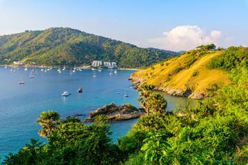 Fototapeta premium Tropical bay at Naiharn and Ao Sane beach with boats at windmill viewpoint, Paradise destination Phuket, Thailand