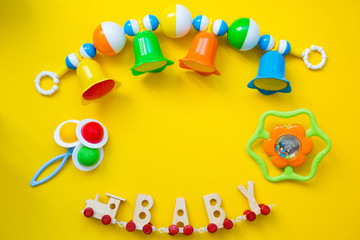 Kid's toys for a newborn baby. Various children's items for the game on a yellow background. Copy...