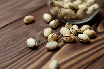 Roasted pistachios on a clay plate. old wood background
