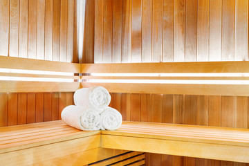 Traditional wooden sauna for relaxation with bucket of water and set of towels