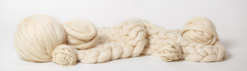 Fototapeta na wymiar Plaid of thick Merino yarn and tangles of yarn on a white background.