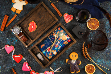Wooden photo box with photo for Valentine's Day or Wedding Day. Decorated with gingerbreads. Romantic or love concept. Gingerbreads for Valentines Day on dark concrete background