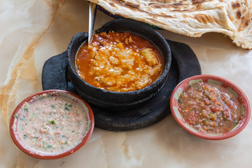 Saltah dish, meze plates and flat bread.
