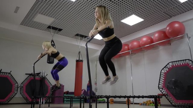 Cute fitness-girls making exercises on rebounder