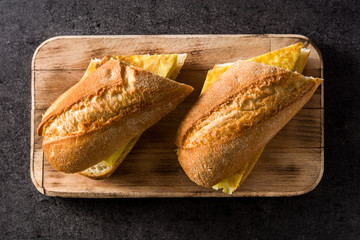 Bocadillo de tortilla española. Spanish potato omelette sandwich on slate background. Top view