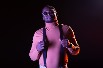 Handsome male touching suspenders of his costume