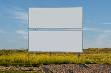 two billboards in a green field.