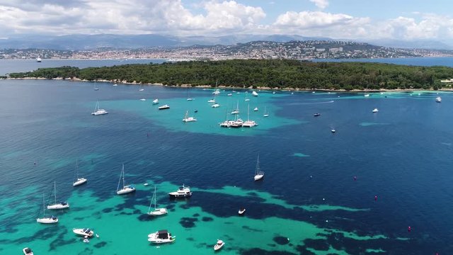 Aerial footage of Plateua du Milieu recreational boats at anchor and Ile Sainte Marguerite which is the largest of Lerins Islands, about half a mile off shore from the French Riviera town of Cannes 4k